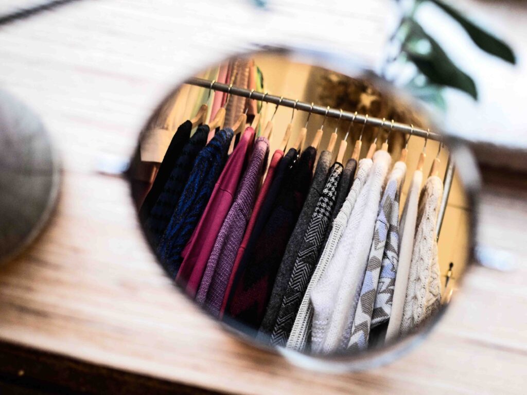 Siti internet. Sito vetrina, immagine di abiti in un negozio riflessa su una lente di occhiali a specchio.