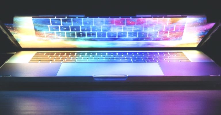 web-design-trends-2024 portatile semiaperto con riflesso arcobaleno su schermo