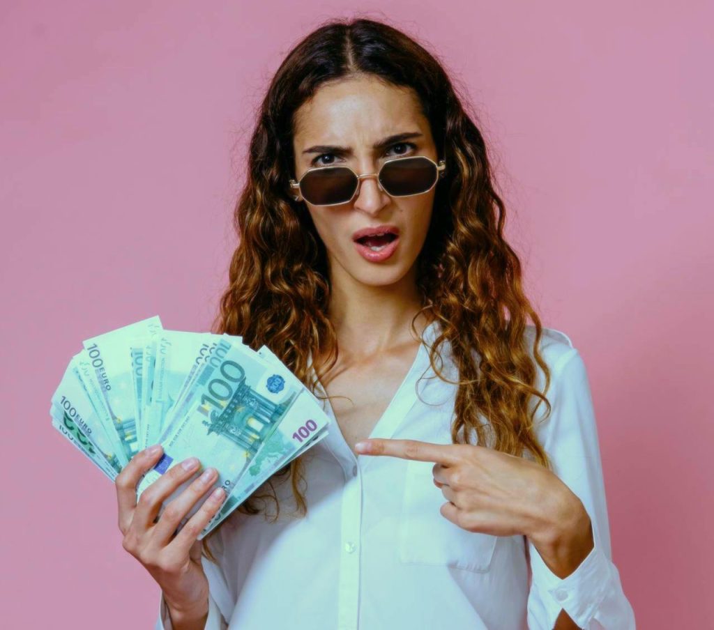 Ragazza con in mano banconote da € 100 con espressione interrogativa. Cos’è un Blog Aziendale